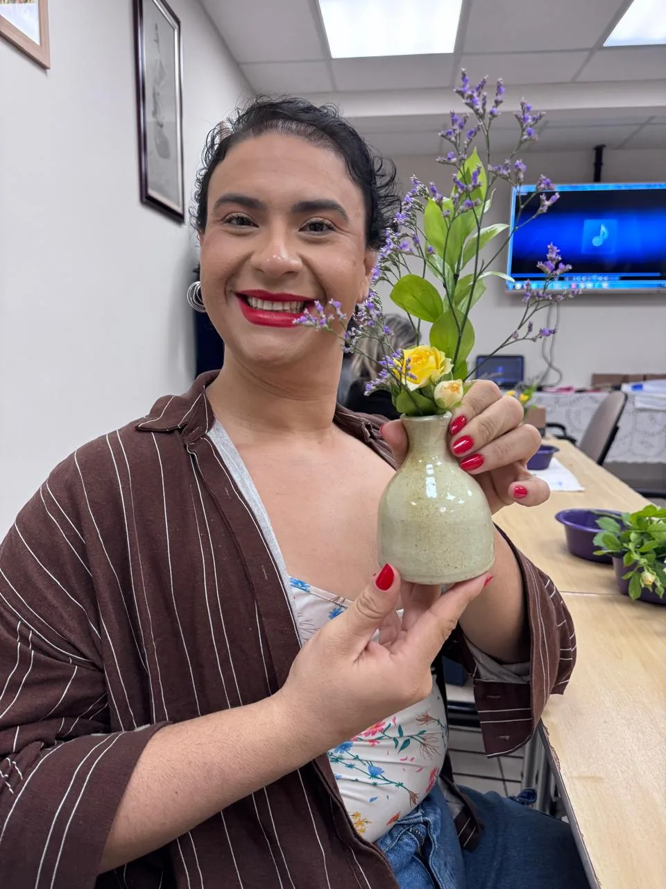 Mathy Lemoss segurando um vaso de flores